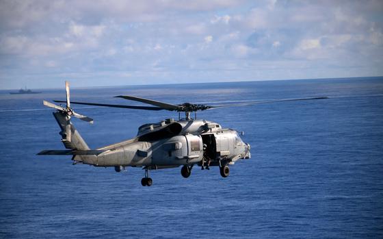 A MH-60S Seahawk helicopter flies toward U.S. warships training alongside a Japanese helicopter destroyer in the Philippine Sea, Nov. 6, 2023. 