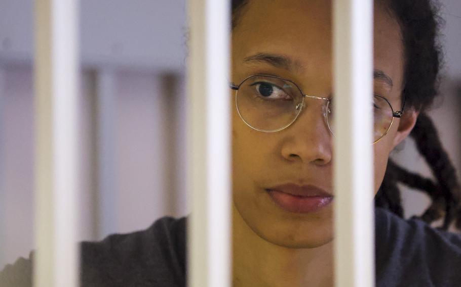WNBA star and two-time Olympic gold medalist Brittney Griner looks through bars as she listens to the verdict standing in a cage in a courtroom in Khimki just outside Moscow, Russia, Thursday, Aug. 4, 2022. 