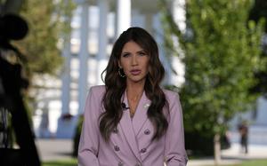 Noem with the White House in the background.