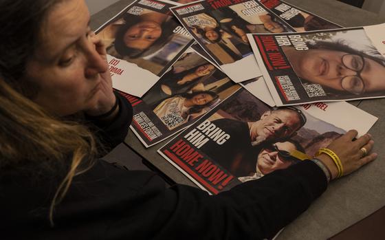 Romina Shvalb, 42, at the dining room table with posters showing her sister Carina Engelbert, 51, with her husband Ronen and daughters Mika, 18, and Yuval, 11. The family was taken from Kibbutz Nir Oz and are believed to be held hostage in Gaza. MUST CREDIT: Heidi Levine for The Washington Post