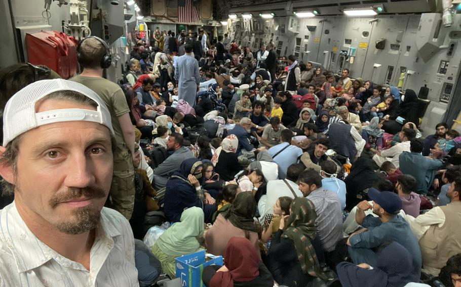 Tim Kennedy, a U.S. Army Green Beret and a mixed martial artist, takes a photo of himself and evacuees inside a U.S. military cargo plane, in an undated photo taken during the evacuation of at-risk people from Afghanistan in the last two weeks of August 2021. Kennedy traveled to Kabul, Afghanistan as a private citizen affiliated with an ad hoc volunteer group that formed to help evacuations. 