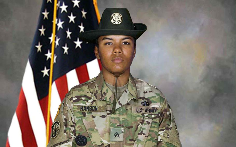Boston Hanson poses in uniform in front of an American flag.