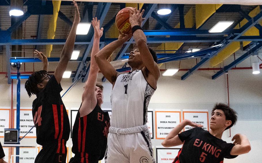 Zama’s Keshawn McNeill pulls up for a shot against E.J. King’s Keith Lombard, Jacob Auger and Cameron Reinhart.