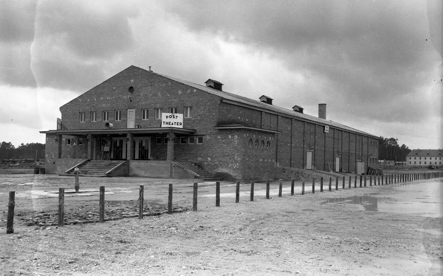 A black and white photo of a long building with a triangular roof.