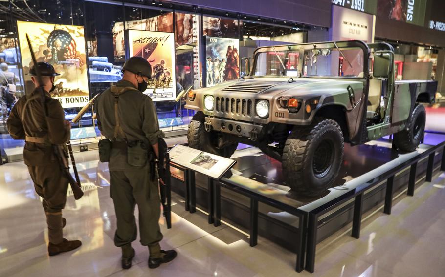 Two active-duty soldiers dressed in period uniforms check out a Jeep at the National Museum of the United States Army on its reopening day, June 14, 2021.