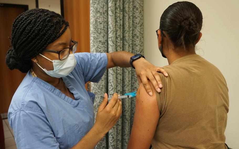 Seaman Dayshia Hall, assigned to U.S. Navy Medicine Readiness and Training Command Sigonella, vaccinates a sailor at Naval Air Station Sigonella, Italy, Sept. 3, 2021.
