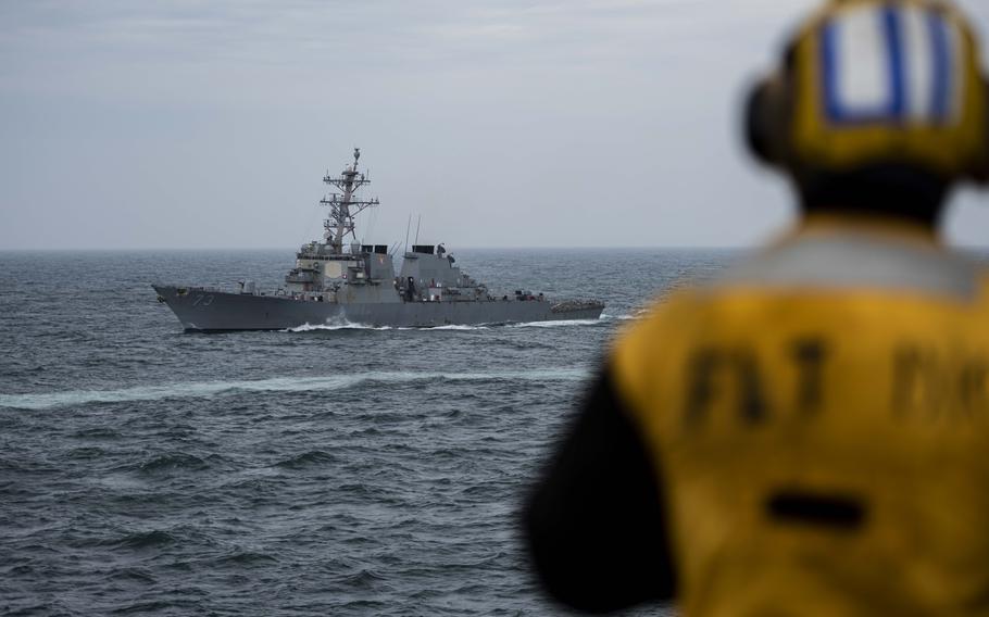 The Arleigh Burke-class guided missile destroyer USS Decatur steams in formation with the aircraft carrier USS Nimitz during a trilateral photo exercise on April 4, 2023, in the East China Sea.