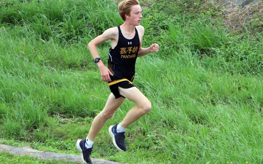 Kadena’s Cullen Oglesbee navigates a gully en route to his second straight Okinawa boys cross country district finals title.