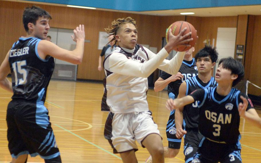 Matthew C. Perry's B.J. Hill drives to the basket between Osan defenders Ben Ziegler and Jax Ibarra. The Samurai won 63-33.