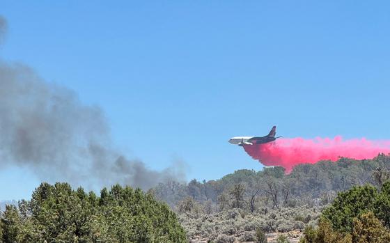 A plane drops red fire retardant. 