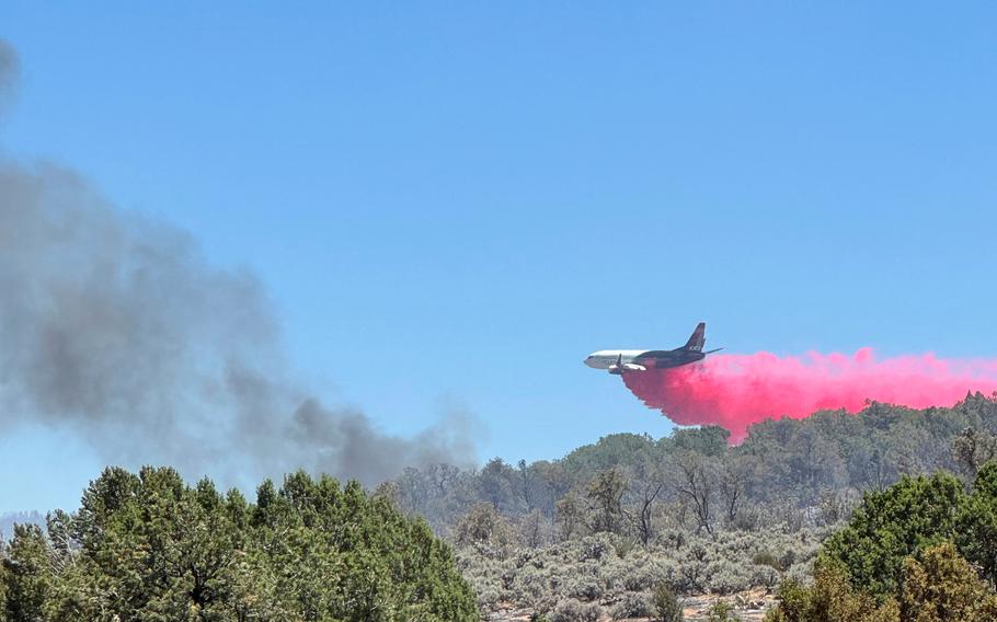 A plane drops red fire retardant. 