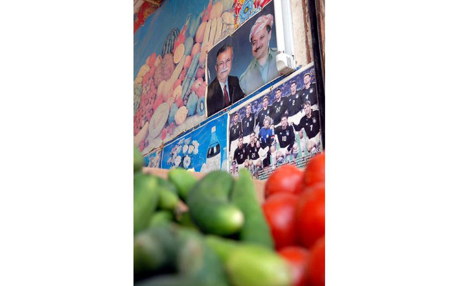 A photo of then-Iraqi President Jalal Talabani, father of the author, Bafel Talabani; and then-Kurdistan Regional Government President Masoud Barzani hangs next to advertisements and posters of famous soccer teams Wednesday at a vegetable store in Khaniqin, Iraq, July 23, 2008. As the U.S. focuses on big global challenges and gets away from American costs in blood and treasure in the Middle East, it must not walk away all together from supporting its allies and friends in the region.