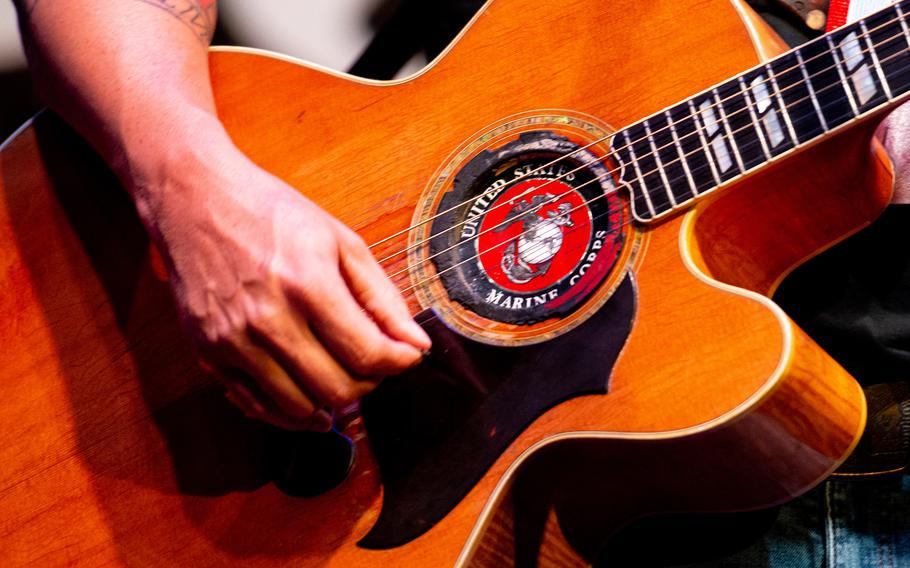 War Hippies member Scooter Brown, a Marine veteran of the 2003 invasion of Iraq, plays with a U.S. Marine Corps branded guitar during a performance March 9, 2023, at MadLife Stage & Studios in Woodstock, Ga., just north of Atlanta.