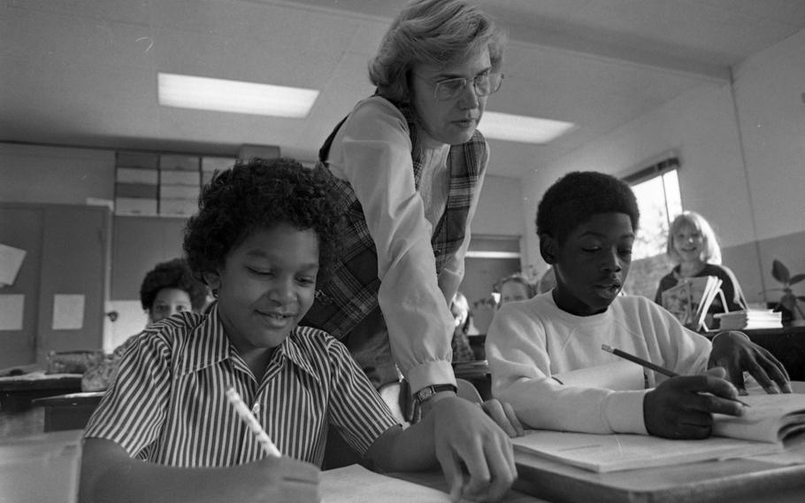 Fourth grade teacher Kathryn Willers with J.T. Williams III, 9, (left) and Derek Dixon, 9, in the classroom. Willers had shown the life-saving film on how to help someone choking 10 days before the incident in her class at Frankfurt Elementary School No. 2. J.T., son of Spec. 4 William and Karen Carroll saved Derek’s life by performing the Heimlich maneuver when he saw his friend choking at lunch. Derek is the son of Spec. 5 Anthony and Myrna Dixon. 