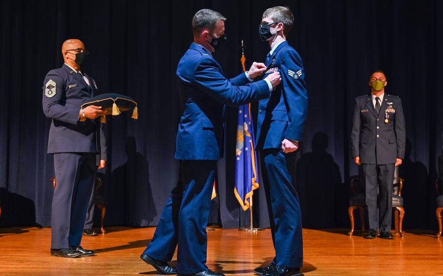 Air Force Col. John Schutte, 19th Airlift Wing commander, presents the Air Medal to Senior Airman Dimitrious Carden, 61st Airlift Squadron loadmaster, at Little Rock Air Force Base, Ark., May 10, 2021. Carden received the Air Medal for decisive actions on a flight in Afghanistan, and for rendering aid to his injured senior loadmaster. 

 Aaron Irvin/U.S. Air Force