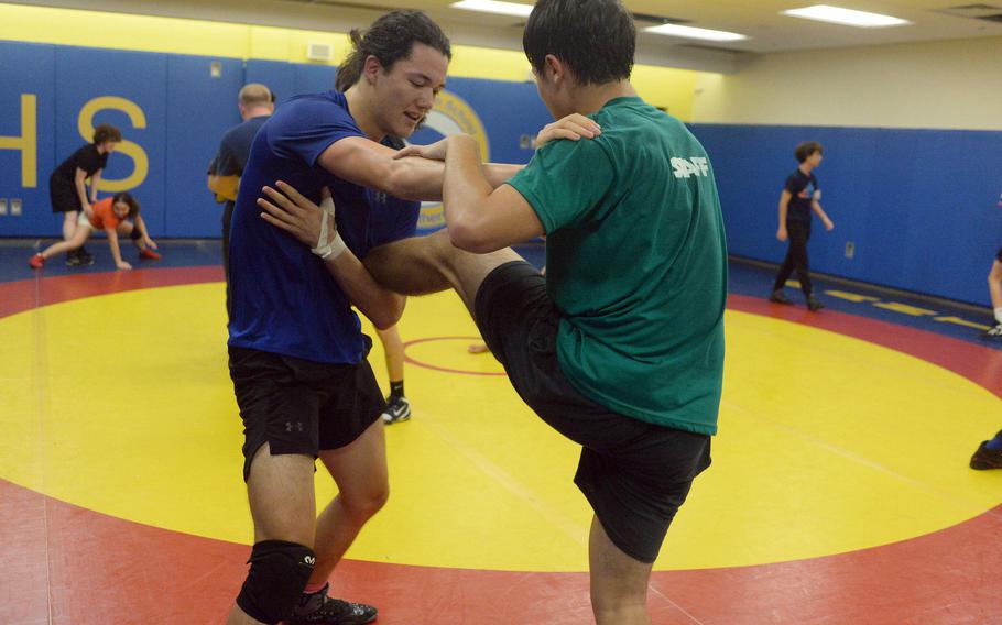 Junior Noah Harbert and senior Kaiyo Heinrichs line up at higher weights on a relatively new Yokota wrestling team.