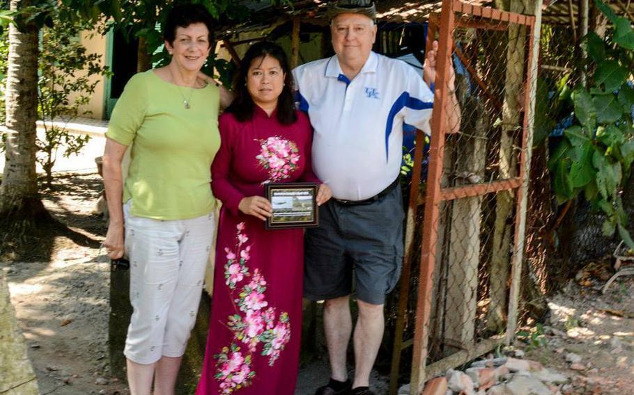 U.S. Air Force retired Col. Regina Aune, Aryn Lockhart, 17th Training Wing Public Affairs visual information specialist and retired Chief Master Sgt. Ray Snedegar stand at the Galaxy C-5A shrine in Saigon, Vietnam November 2014. 