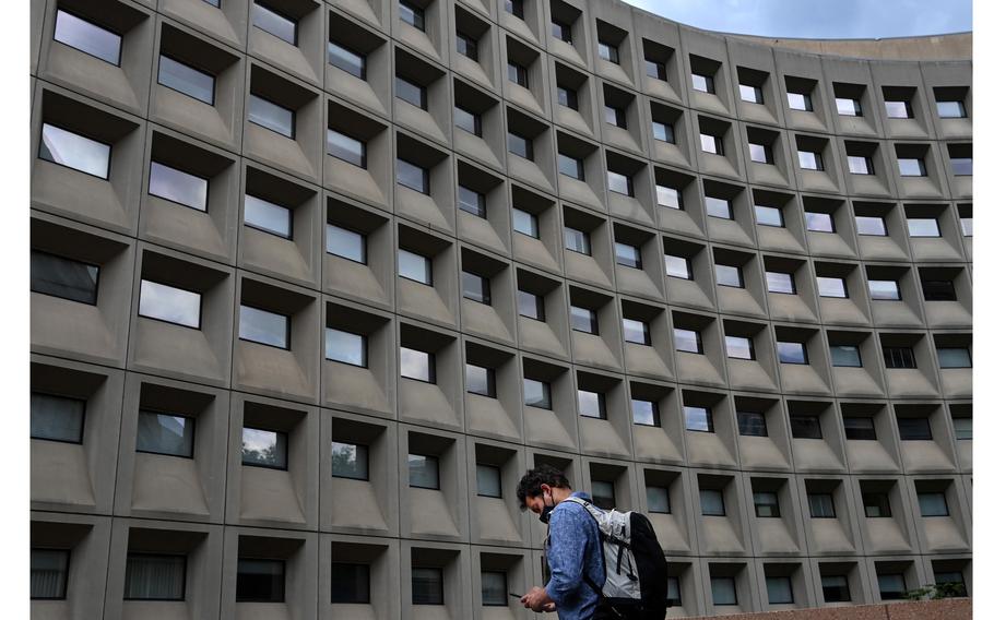 A pedestrian walks near the Department of Housing and Urban Development on May 17, 2021, in Washington, D.C. Two months after the Biden administration’s deadline for federal workers to be vaccinated against coronavirus so they could begin returning to the office, the government’s plan to resume normal operations remains muddled.