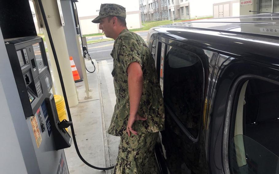 Navy Petty Officer 1st Class Jeffrey Hoffman fuels up his personal vehicle at Marine Corps Air Station Iwakuni, Japan, Thursday, Aug. 11, 2022.