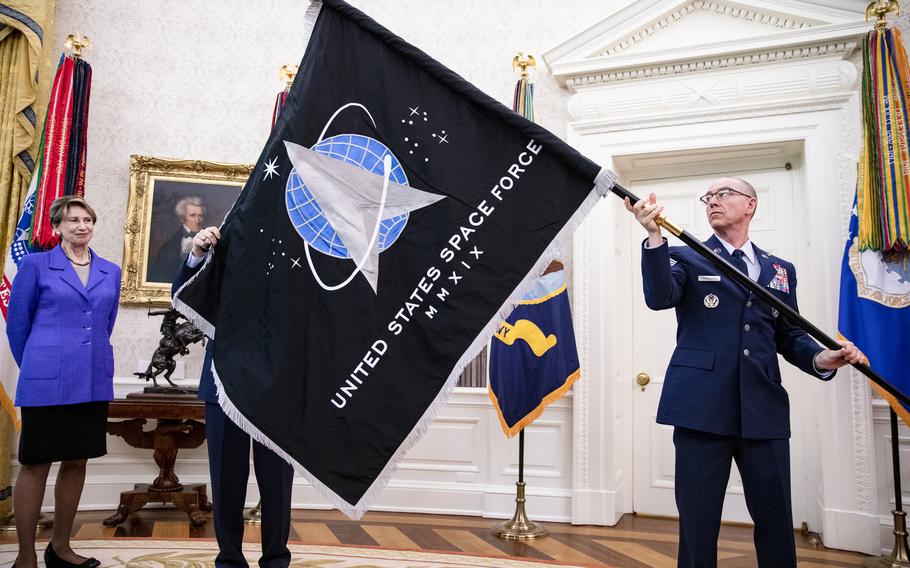 Chief Master Sgt. Roger Towberman (R),  Space Force and Command Senior Enlisted Leader and CMSgt Roger Towberman (L), with Secretary of the Air Force Barbara Barrett, present US President Donald Trump with the official flag of the United States Space Force in the Oval Office of the White House in Washington, DC on May 15, 2020. (Samuel Corum/Pool/Getty Images/TNS)