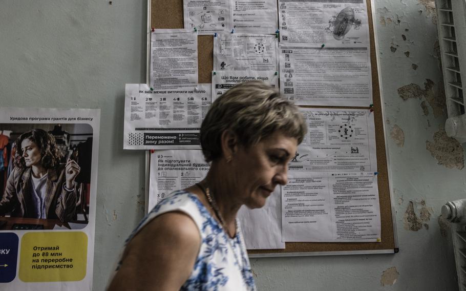 A woman passes by a board last week at the Tomakivka council building with detailed instructions about what to do in case of a nuclear threat. 