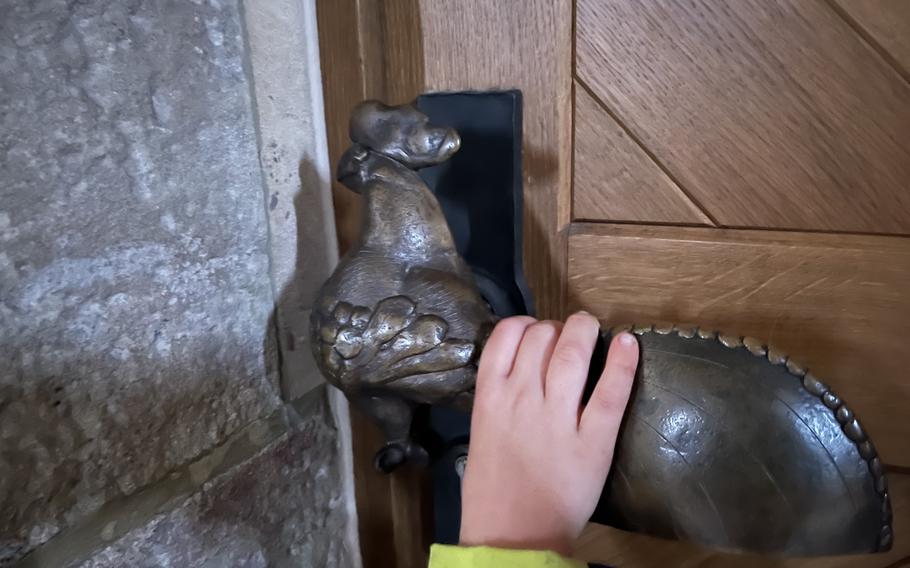A church door handle is shaped like a rooster.