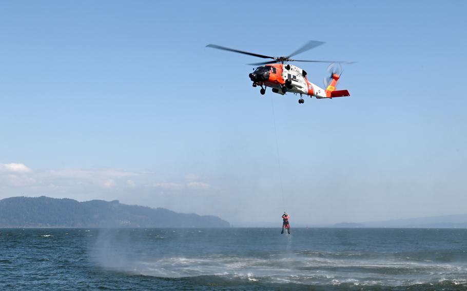 An MH-60 Jayhawk helicopter crew from Coast Guard Sector Columbia River hoists an aviation survival technician from the Columbia River during rescue training in Warrenton, Oregon, Tuesday, April 20, 2021.