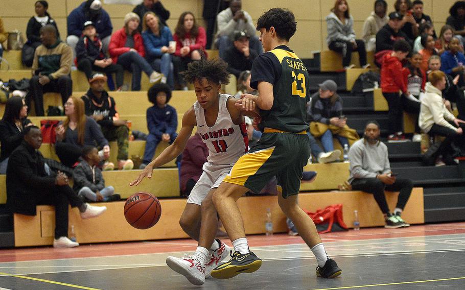 Raider guard Sevastian Quiles drives while SHAPE's Aberto Saldana defends during a Jan. 12, 2024, game at Kaiserslautern High School in Kaiserslautern, Germany.