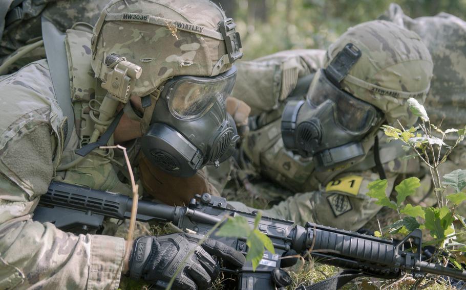 Soldiers with guns and gas masks.