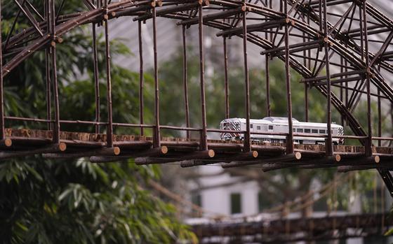 A train sits on a bridge during the preparations for the annual Holiday Train Show at the New York Botanical Garden in New York, Thursday, Nov. 11, 2021. The show, which opens to the public next weekend, features model trains running through and around New York landmarks, recreated in miniature with natural materials. 
