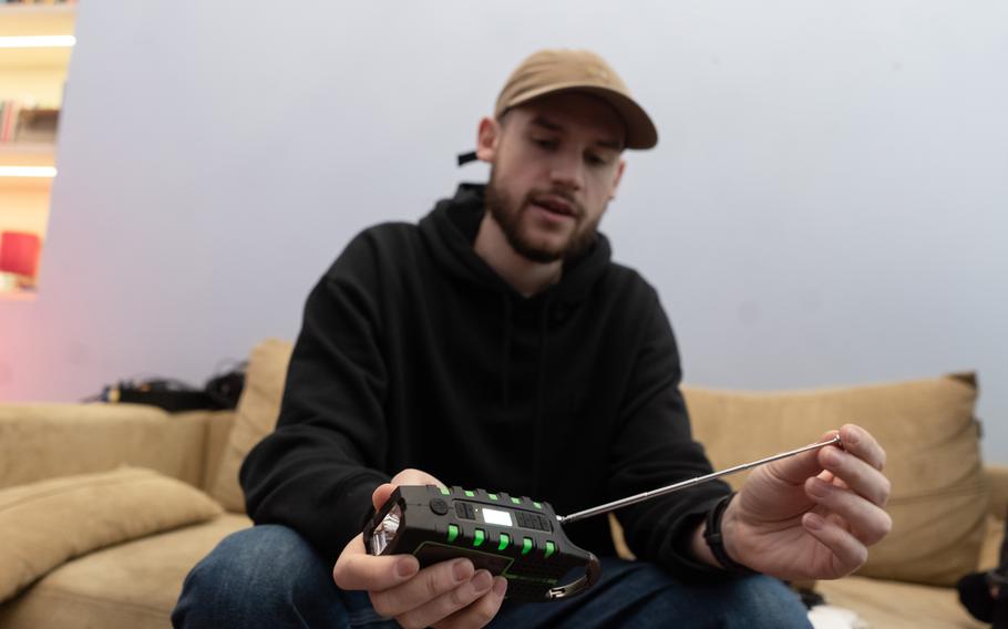 Serhiy Dmytruk with his favorite item from his survival backpack - a combination radio, flashlight, windup charger and bottle opener. 