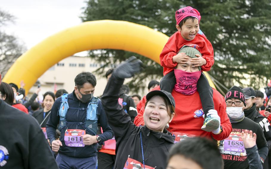 People participate in a 2-kilometer family run during the 42nd annual Yokota Striders Frostbite Road Race at Yokota Air Base, Japan, Sunday, Jan. 22, 2023.