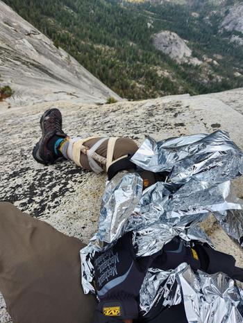 A climber awaits evacuation after receiving Tactical Combat Casualty Care  at Yosemite National Park in California, Sept. 2, 2023. U.S. Air Force Capt. Joshua Haveman, 60th Air Evacuation Squadron flight instructor, was involved in the rescue of a climber on Half Dome after inclement weather caused unfavorable climbing conditions. 