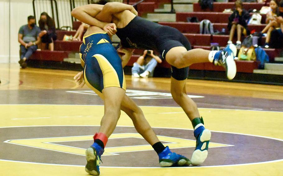 Guam High's Chris Angoco performs a right-shoulder throw on Simon Sanchez's Thomas Santiago; Santiago won the bout by pin in 3 minutes, 29 seconds.