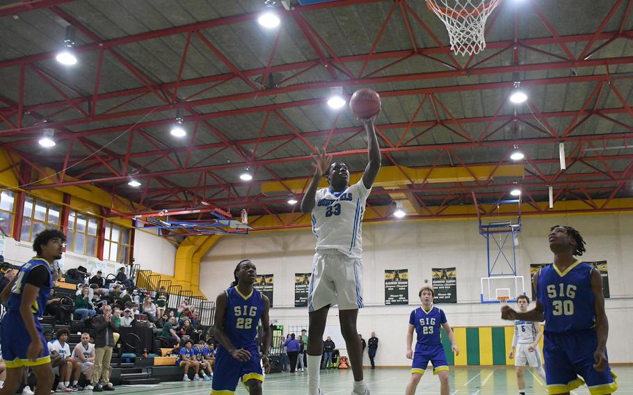 Hohenfels’ Jacob Idowu goes for a layup following an offensive rebound against the Sigonella Jaguars on Saturday. Idowu scored 47 points over two games, leading his team in scoring for the weekend. 