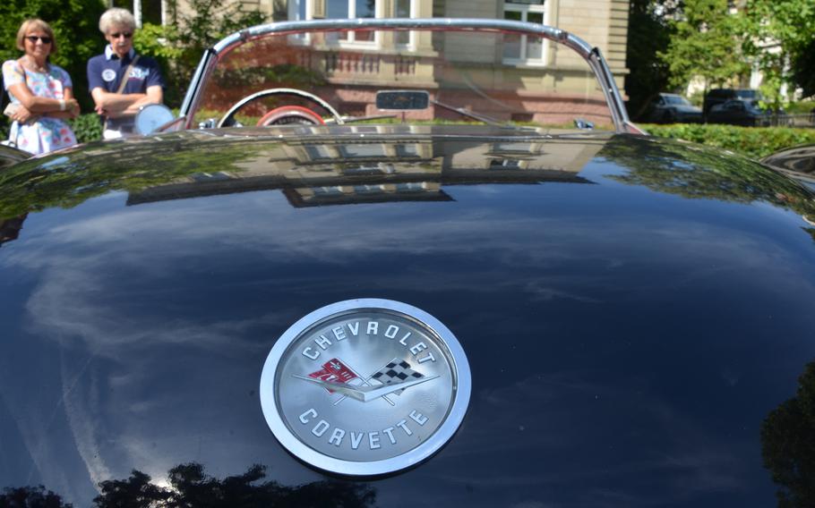 Women sit near a vintage Chevrolet Corvette in Bad Nauheim, Germany, on Aug. 15, 2021.  The Corvette was one of many classic cars that were in the spa town for the European Elvis Festival, a tribute to Elvis Presley, who lived in Bad Nauheim when he was a soldier, from 1958-1960. 