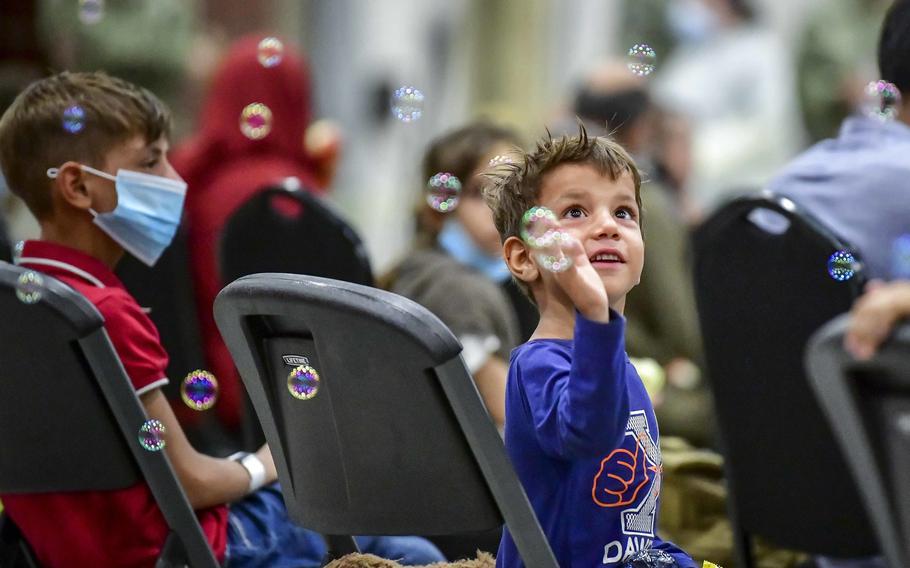 An Afghan child evacuee plays with bubbles after arriving at Naval Air Station Sigonella, Sicily, Aug. 22, 2021.