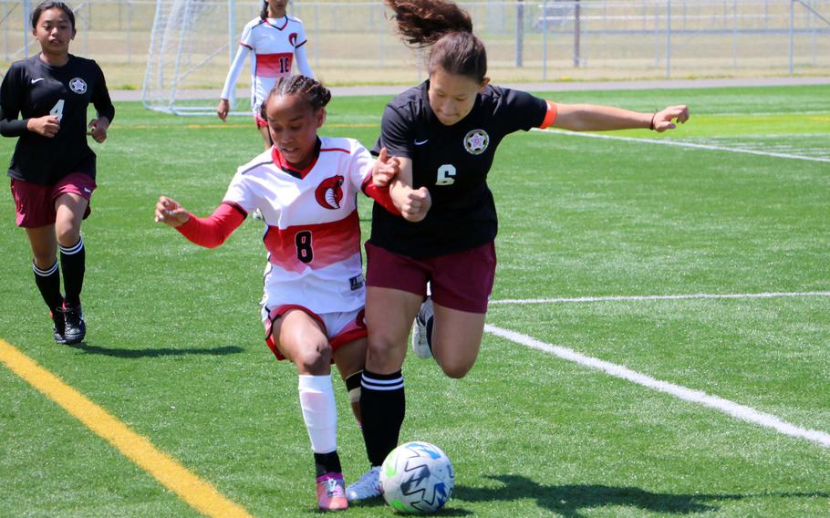 E.J. King’s Miu Best and M.C. Perry’s Sasha Malone scuffle for the ball during Wednesday’s girls Division II soccer playoff match. Malone and the Samurai dethroned the defending champion Cobras 1-0.