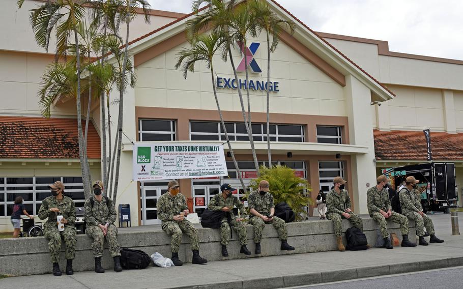 Service members wear masks as they relax outside the exchange at Kadena Air Base, Okinawa, Friday, Jan. 21, 2022. 