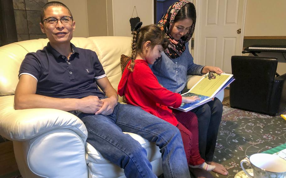 Mohammed Naiem Asadi, his wife Rahima and their daughter Zainab, 5, relax at their home in the suburbs of Atlantic City, N.J., on Oct. 26, 2021. Asadi, a former helicopter pilot, left Afghanistan in June, months before the Taliban's takeover of the country.