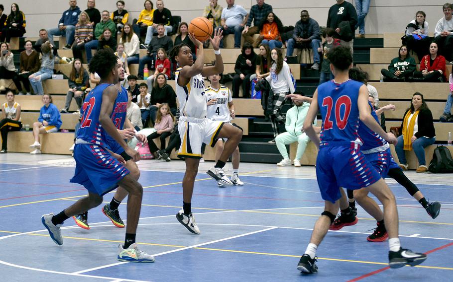 Stuttgart's Tyler Jackson puts up a floater during the Panthers' 55-43 win over Ramstein on Saturday afternoon at Ramstein High School. Defendiers include Samuel Udoaka, left, and Dominic Brooks.