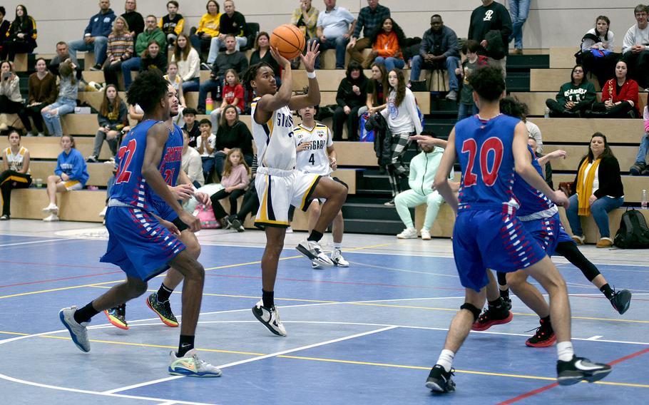 Stuttgart's Tyler Jackson puts up a floater during the Panthers' 55-43 win over Ramstein on Saturday afternoon at Ramstein High School. Defendiers include Samuel Udoaka, left, and Dominic Brooks.