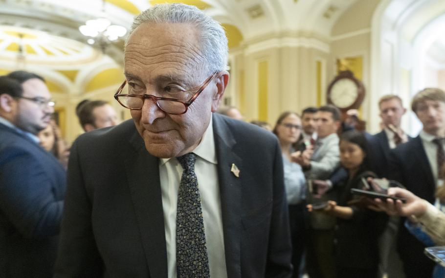 Chuck Schumer from the chest up in a suit, with his head bowed slightly as he looks at something off-camera.