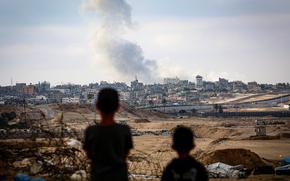 Boys watch smoke billowing during Israeli strikes east of Rafah in the southern Gaza Strip on May 13, 2024, amid the ongoing conflict between Israel and the Palestinian militant group Hamas. (AFP via Getty Images/TNS)