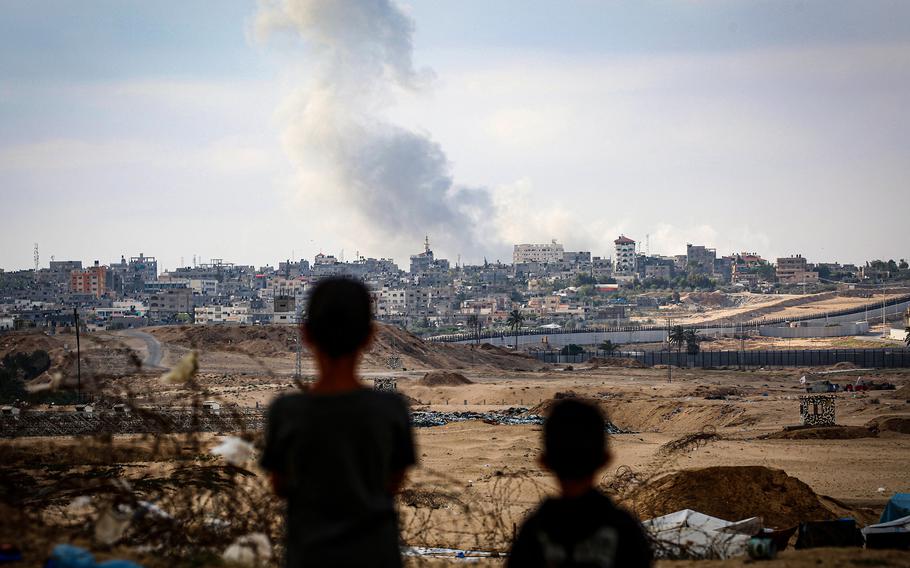 Boys watch smoke billowing during Israeli strikes east of Rafah in the southern Gaza Strip on May 13, 2024, amid the ongoing conflict between Israel and the Palestinian militant group Hamas.