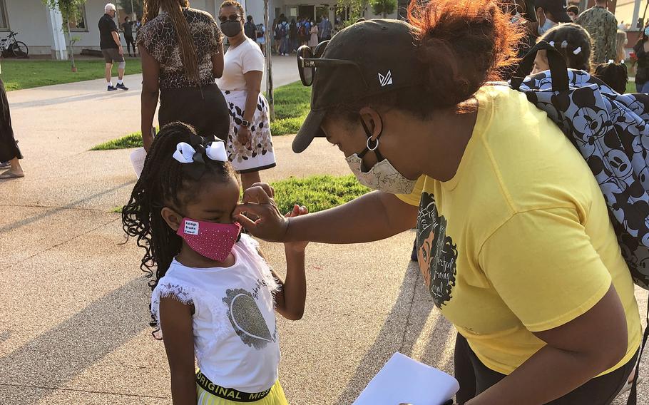 Keturah Ernest and her 6-year-old daughter, Kaleigh B, get ready to take back-to-school photos outside Naples Elementary School at the Gricignano di Aversa site on Naval Support Activity Naples, Monday, Aug. 23, 2021.  