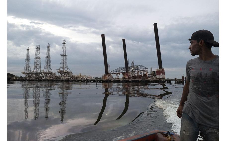 A fisherman passes some of the dilapidated infrastructure of the Venezuelan state-run oil company on Lake Maracaibo in Cabimas on May 9, 2019.   