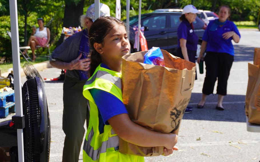 A girl carries a paper bag.