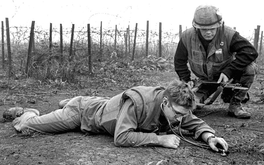 Khe Sanh, South Vietnam, March 1968: Hospital Corpsman Theodore Rutkowski of Pittsburgh lies on the ground just outside of Khe Sanh's outer defenses and uses a stethoscope to listen for signs of Viet Cong tunneling beneath the beleaguered base.