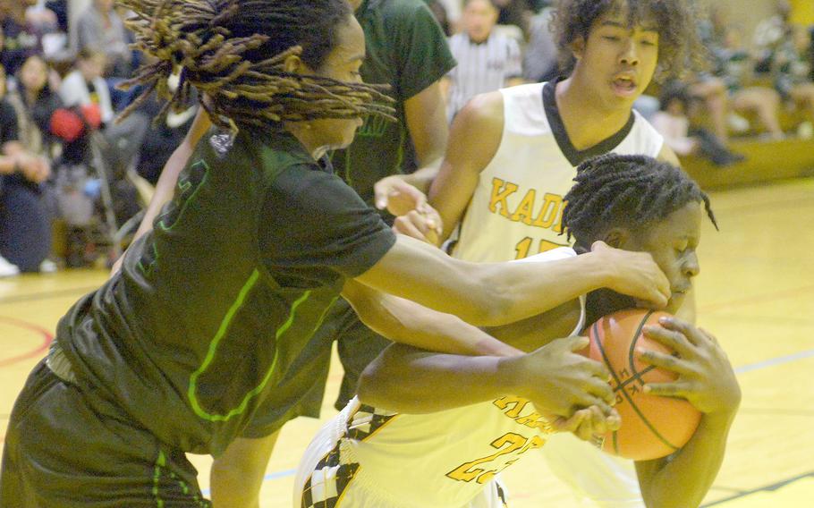 Kadena's Sebastian Dorelein tries to keep the ball away from Kubasaki's Carlos Cadet during Friday's Okinawa boys basketball game. The Panthers won 49-44, completing a four-game season-series sweep of the Dragons.